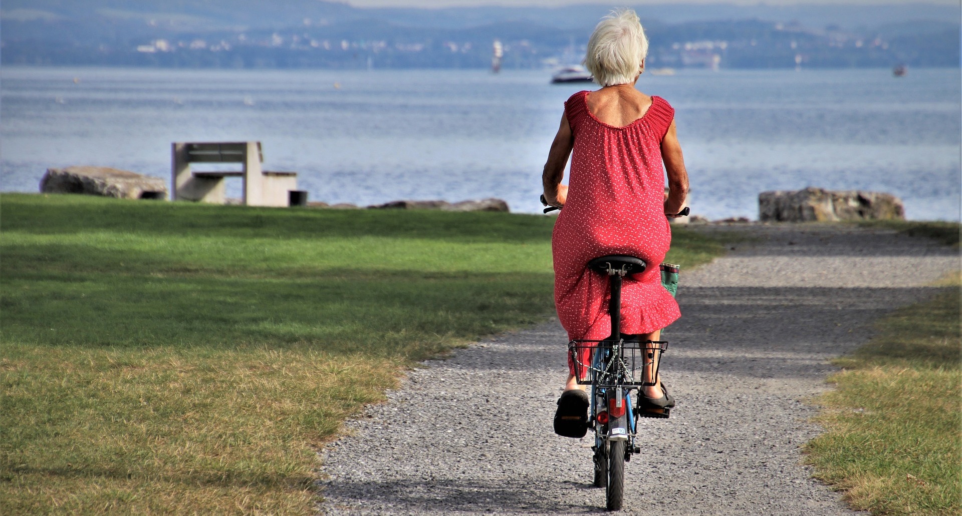 Older woman out on bicycle near seaside